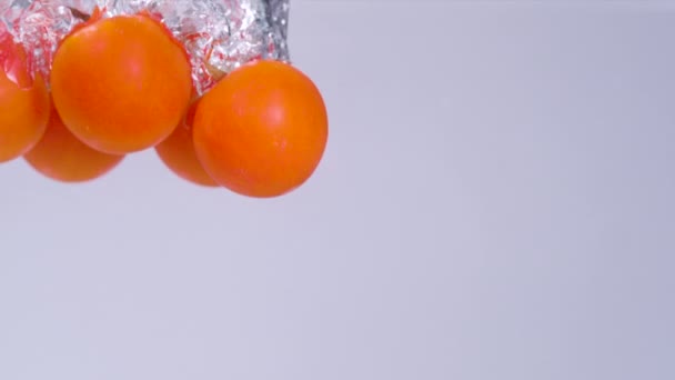 UNDERWATER, COPY SPACE: Reife süße Tomaten fallen ins kristallklare Wasser. — Stockvideo