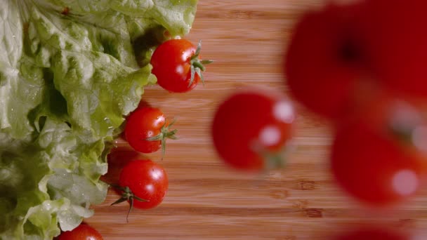 ARRIBA: Toma cinematográfica de tomates mojados cayendo y rodando alrededor de una encimera — Vídeo de stock