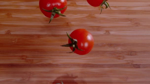 ТОП СКАЧАТИ: промиті вишневі помідори потрапляють на порожню дерев'яну обробну дошку . — стокове відео