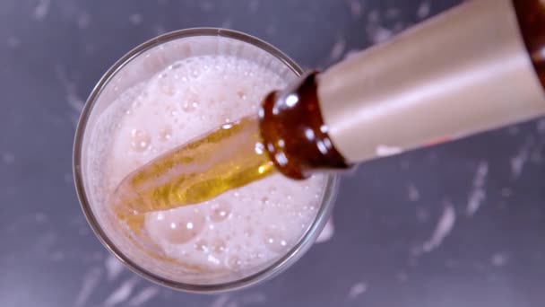 TOP DOWN, DOF: Delicious frothing pale ale gets poured from a retro bottle. — Stock Video