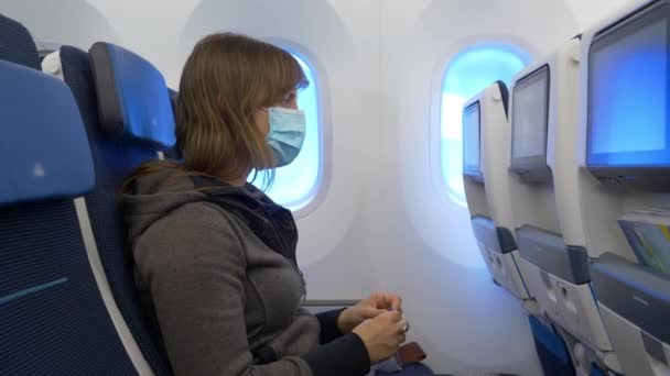 Κοντινό πλάνο: Νεαρή γυναίκα ταξιδιώτης ετοιμάζεται να δει μια ταινία κατά τη διάρκεια μιας πτήσης. — Αρχείο Βίντεο