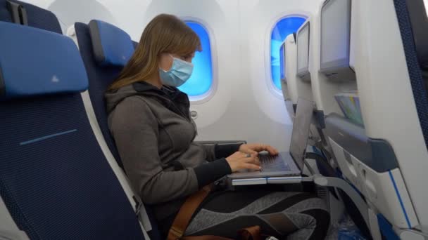 CERRAR: Mujer productiva en un largo vuelo internacional está trabajando en el ordenador portátil — Vídeo de stock