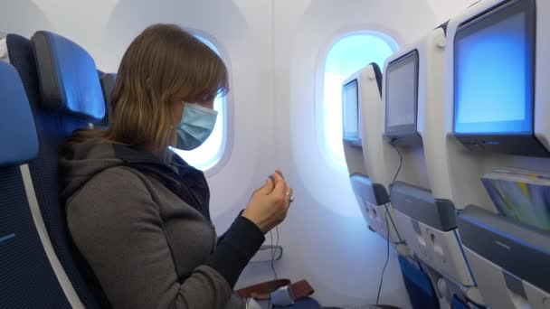 FERMER : Femme portant un masque se prépare à regarder le film en volant dans un jet. — Video