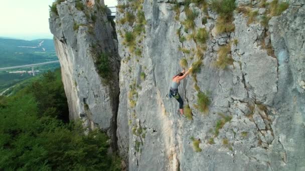 ESPACE DE COPIE : Vue par drone d'une escaladeuse gravissant une falaise difficile — Video