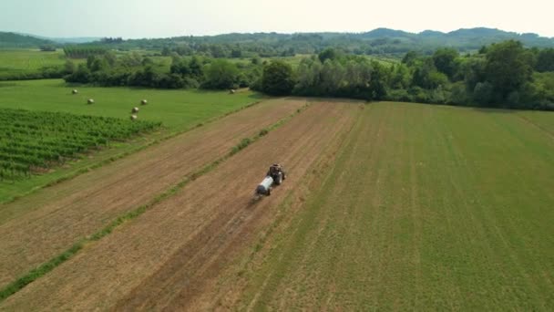 AERIAL: Agricultor que opera um trator fertiliza a fazenda cultivada na região vinícola. — Vídeo de Stock