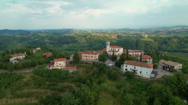 AERIAL: Rustig historisch dorp bovenop een weelderige heuvel op het Sloveense platteland. — Stockvideo