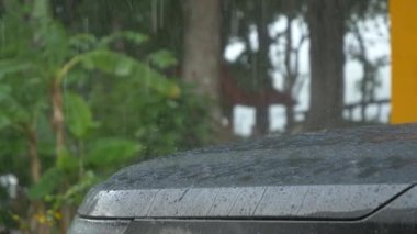 Gri arabanın kaputuna bardaktan boşanırcasına yağmur damlaları yağıyor.