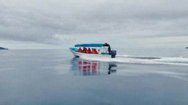 Turistik tekne, egzotik bir ada gezisine can yelekli turistleri götürüyor.