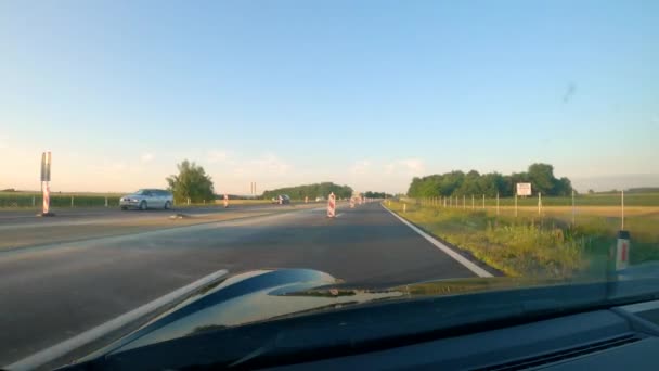 STÄNGA UPP: Svartfärgade sportbil kryssningar längs motorvägen under vägarbeten. — Stockvideo