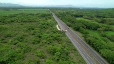 Panama yağmur ormanlarını geçen dünyaca ünlü asfalt karayolu boyunca trafik akıyor. Panamerikan otoyolunun yemyeşil tropikal kırsalda uzanan muhteşem hava manzarası.