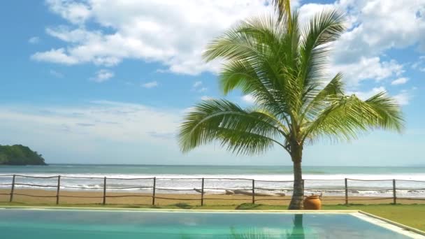 スローモーション エキゾチックなリゾートでスイミングプールの上に海の景色の移動ショット 強いうねりが熱帯砂のビーチを打つ パナマのエキゾチックな夏の目的地 — ストック動画