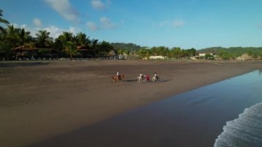 Playa Veano plajında at binme macerasında bir aile. Panama 'daki egzotik turist merkezinde at binme turuna rehberlik etmiş. Seyahat eden aile için aktif tatil.