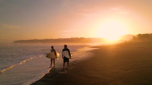 Aerial Silhouette 一对带着冲浪板在海滩上行走的冲浪者 夕阳西下冲浪后 冲浪朋友们在金色的灯光下观看海浪 巴拿马Playa Venao美丽的风景 — 图库视频影像