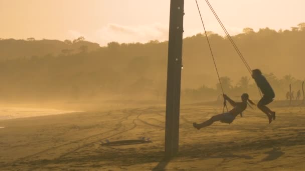 Moving Shot Casal Jovem Balançando Praia Nebulosa Tropical Pôr Sol — Vídeo de Stock