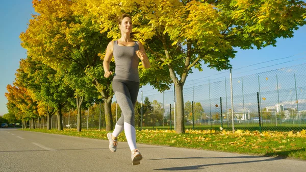 Low Angle Zdjęcia Młodej Biegaczki Biegającej Tętniącym Życiem Kolorowym Chodniku — Zdjęcie stockowe