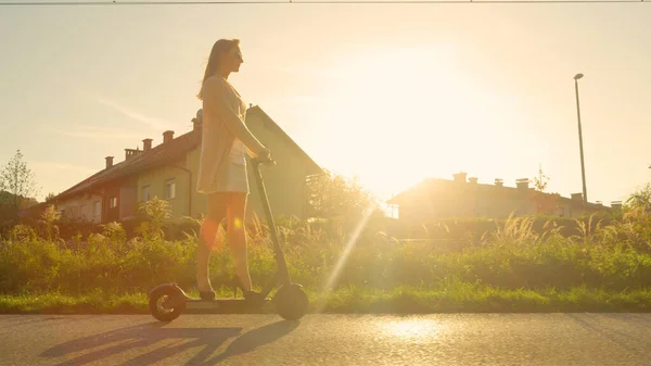 Low Angle Lens Flare Jonge Vrouw Rijdt Een Elektrische Scooter — Stockfoto