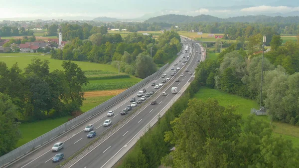 Drone Lecąc Wzdłuż Długiego Korku Utworzonego Asfaltowej Autostradzie Przecinającej Sielankową — Zdjęcie stockowe