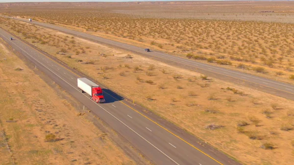 Rode Vrachtauto Vervoert Een Zware Container Door Het Dorre Landschap — Stockfoto
