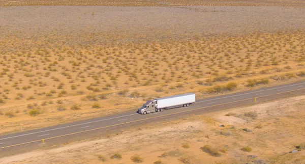 Aerial Zdjęcia Ciężarówki Ładunkiem Jadącej Malowniczą Asfaltową Autostradą Przez Pustynię — Zdjęcie stockowe