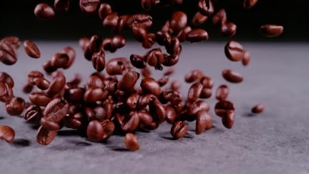 超级慢速运动 证明Lens 在灰色背景上喷出一堆芳香的咖啡颗粒 烤咖啡种子在超级慢动作 咖啡豆朝照相机飞去的详细图像 — 图库视频影像