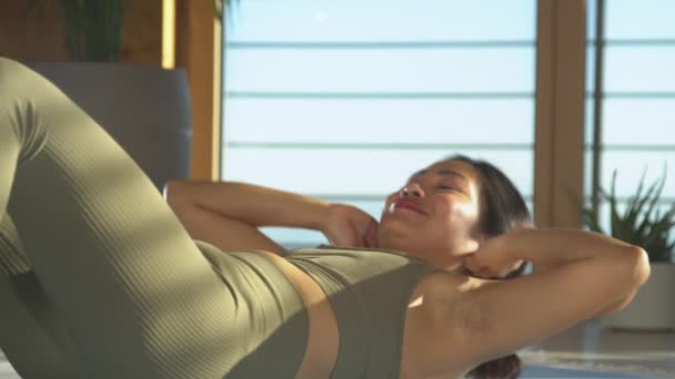 微笑的菲律宾女人做腹肌运动 看着镜头 漂亮的女士在腹部运动训练 年轻女子穿着运动服参加健身活动以保持健康 — 图库视频影像