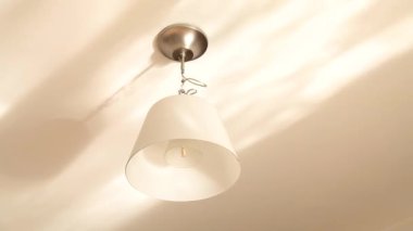 Tavandaki sudan yansıyan avize ve parıltı.