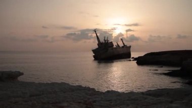 Gün batımında karaya vuran bir gemi.