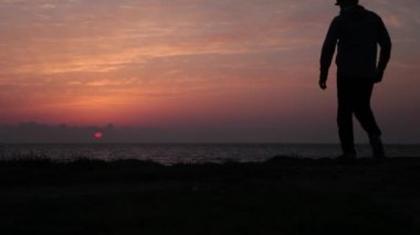 Güzel bir deniz batımında bir adamın silueti.
