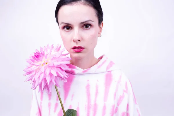 woman in pink holding a pink flower