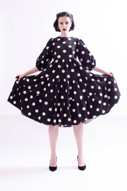 Kırmızı dudaklı, puantiyeli güzel bir kadın.