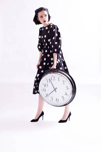 Femme Dans Une Robe Pois Tient Une Grande Horloge Dans Images De Stock Libres De Droits