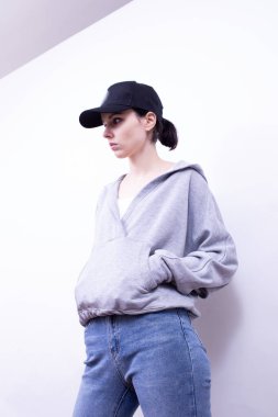 Gri kazaklı ve kot pantolonlu kız.