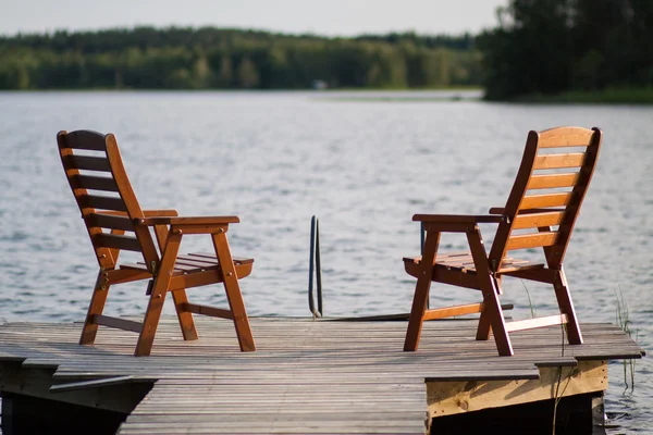 Cadeiras de madeira sentadas na doca — Fotografia de Stock