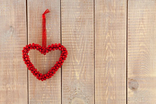 Red heart hanging over wooden background — Stock Photo, Image