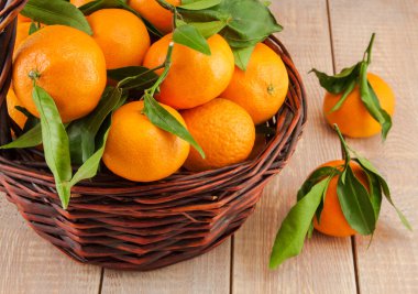 sepet içinde yapraklarla olgun mandalina