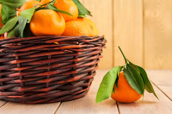 Mandarini maturi con foglie in un cesto — Foto Stock