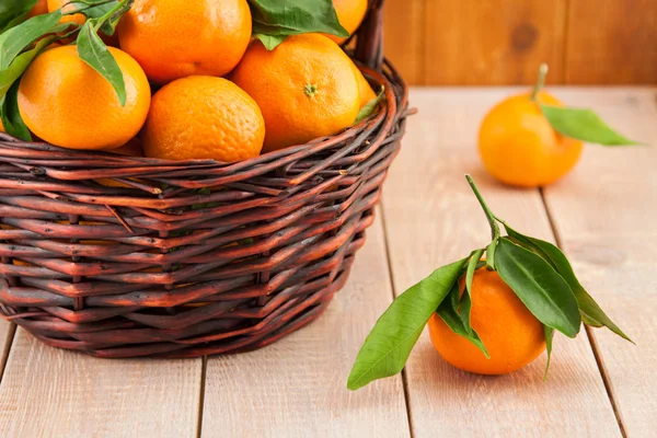 Ripe mandarins with leaves in a basket — Stock Photo, Image