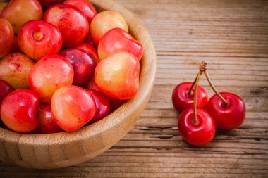 Rainier kiraz ahşap arka plan üzerine bir kase