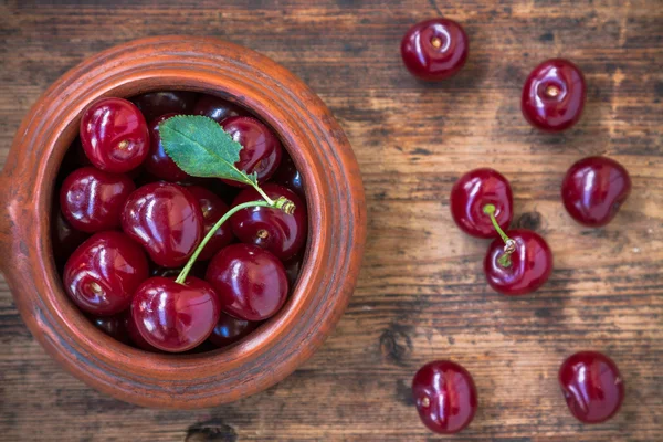 Bowl of cherries on old wooden background — Stock Photo, Image