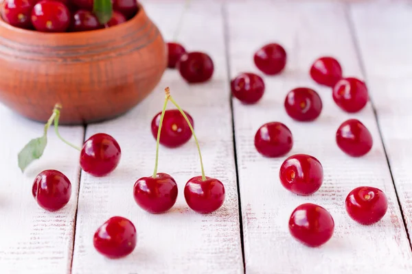 Juicy ripe cherry on a white wooden background — Stock Photo, Image