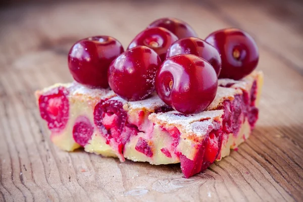 Bit av körsbärspaj på trä bakgrund — Stockfoto