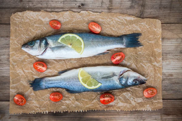2 つの生のシーバス魚レモン スライスと w にチェリー トマト — ストック写真
