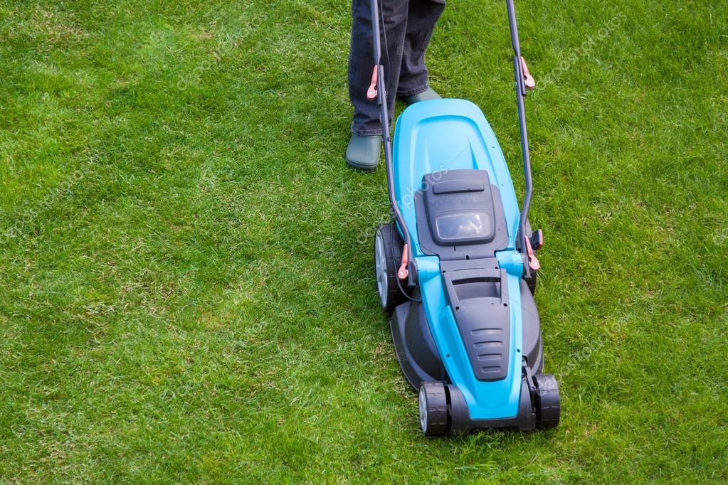 Hombre con una segadora eléctrica sobre hierba verde: fotografía de ...