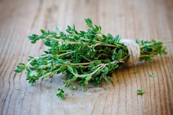 Bunch of fresh thyme on a wooden background — Stock Photo, Image