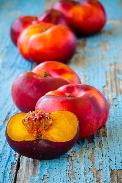 Fresh organic flat nectarines on an old wooden background — Stock Photo, Image