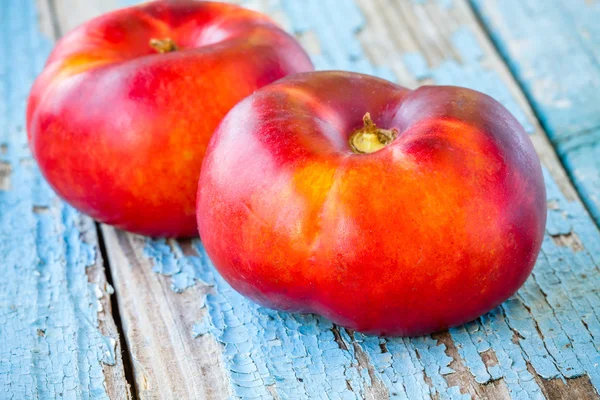 Verse biologische platte nectarines op een oude houten achtergrond — Stockfoto