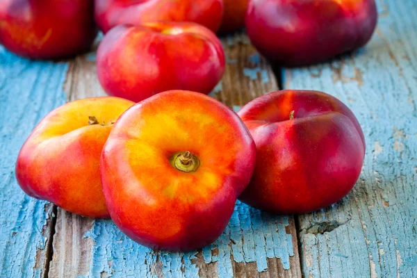 Fresh organic flat nectarines on an old wooden background — Stock Photo, Image