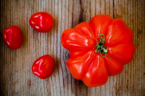 Свежие красные фамильные помидоры на деревянном фоне — стоковое фото