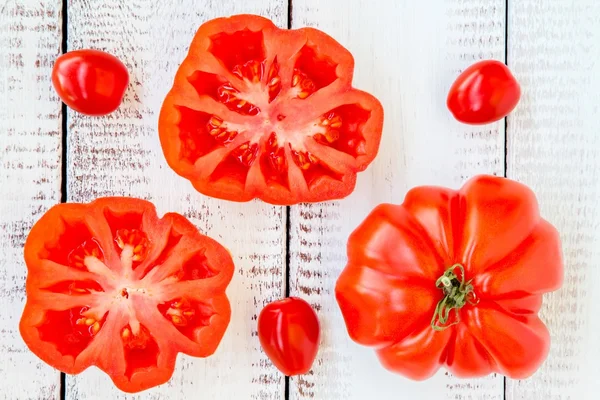 Tomates de relíquia vermelhos frescos em um fundo de madeira — Fotografia de Stock