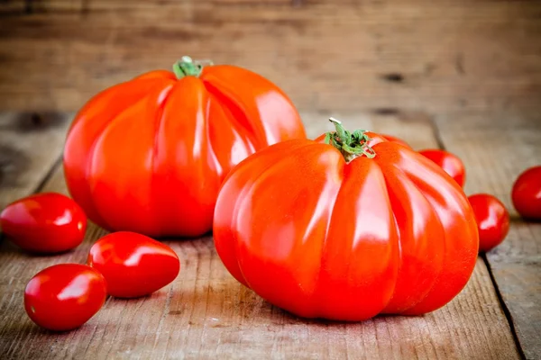 Färska röda heirloom tomater på en trä bakgrund — Stockfoto